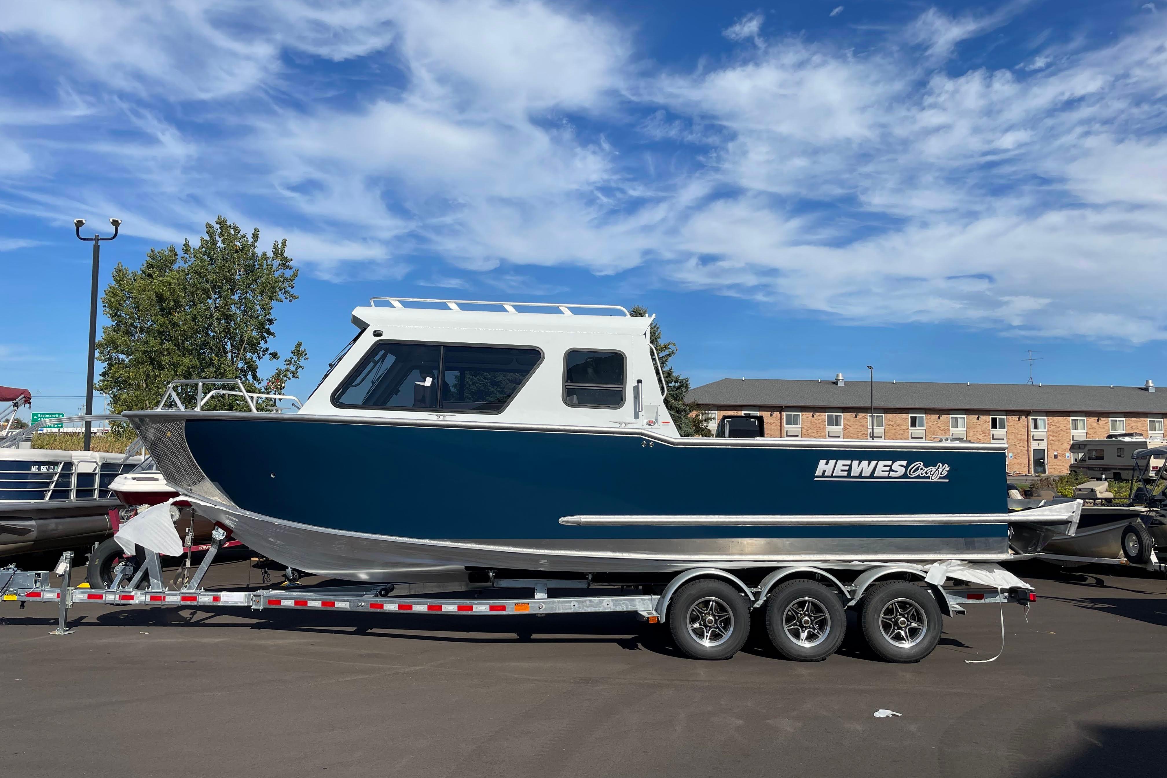 Hewescraft 270 ALASKAN ET HT 2026 Hewescraft 270 Alaskan ET HT boat on trailer under blue sky.