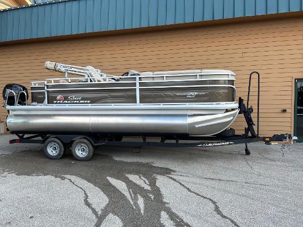 Sun Tracker SportFish 20 DLX 2025 Sun Tracker SportFish 20 DLX pontoon boat on trailer, parked outdoors.