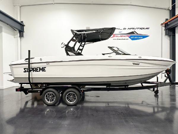 Supreme S240 2025 Supreme S240 boat on trailer in showroom, side view.