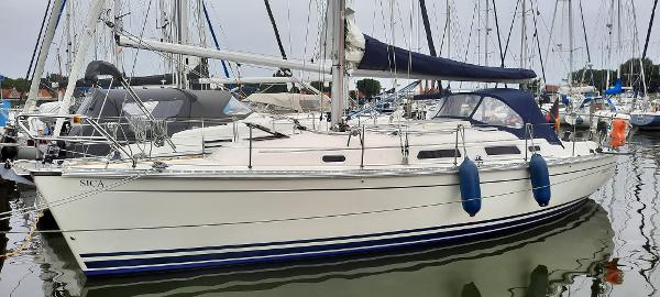Hanse 341 2004 Hanse 341 sailboat docked in a marina, featuring a sleek white hull and blue accents.