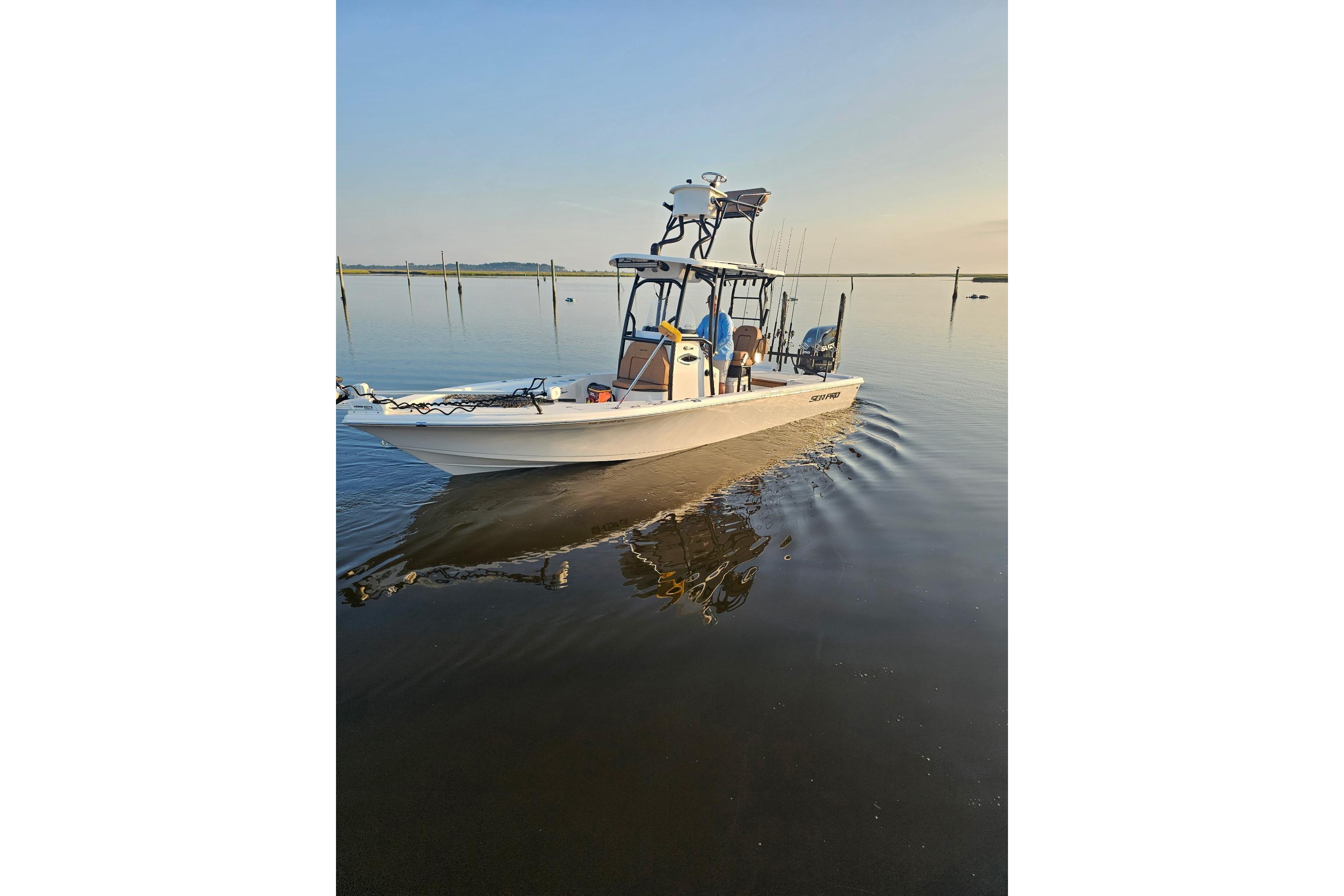 Sea Pro 250 Bay 2024 Sea Pro 250 Bay boat cruising on calm water at sunrise.