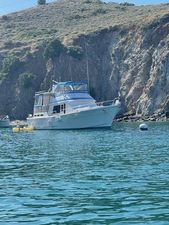 Offshore Yachts 48 Yachtfisher 1988 Offshore Yachts 48 Yachtfisher anchored near rocky coastline.