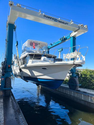 Bluewater Yachts Coastal Cruiser 1987 Bluewater Coastal Cruiser being lifted by a Marine Travelift at a marina.