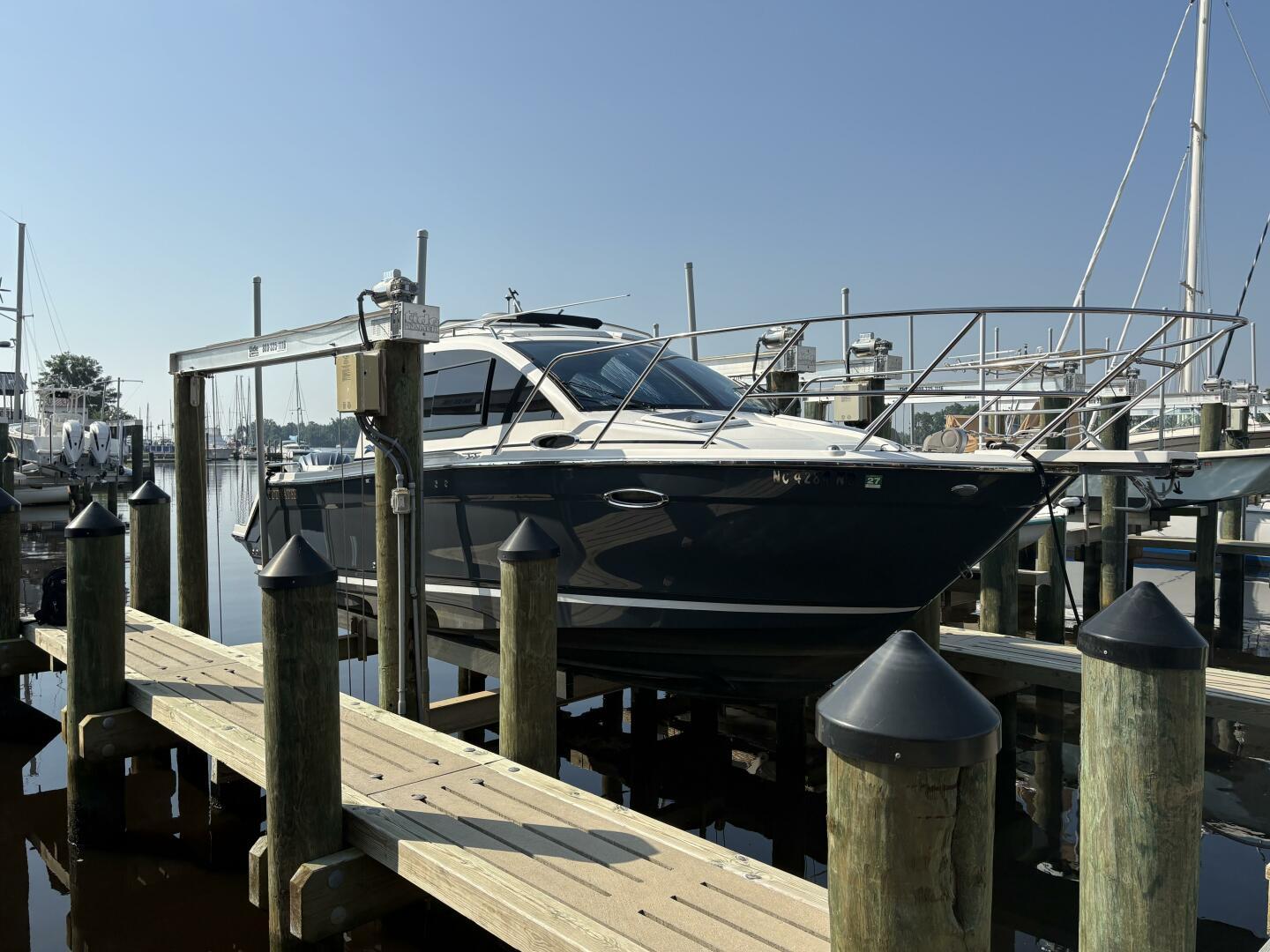 Cutwater C-24 Coupe 2022 Cutwater C-24 boat docked at a marina under clear blue skies.