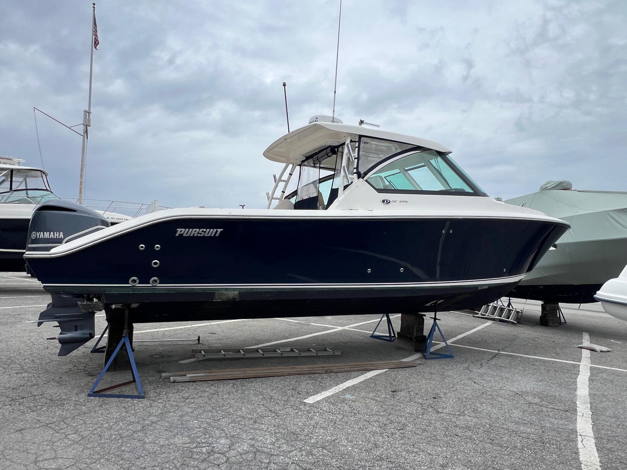 Pursuit 325 DC 2016 Pursuit 325 DC boat on stands in a marina setting.