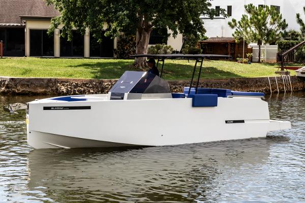 De Antonio Yachts D28 Open 2024 De Antonio Yachts D28 Open cruising on a calm river near a residential area.