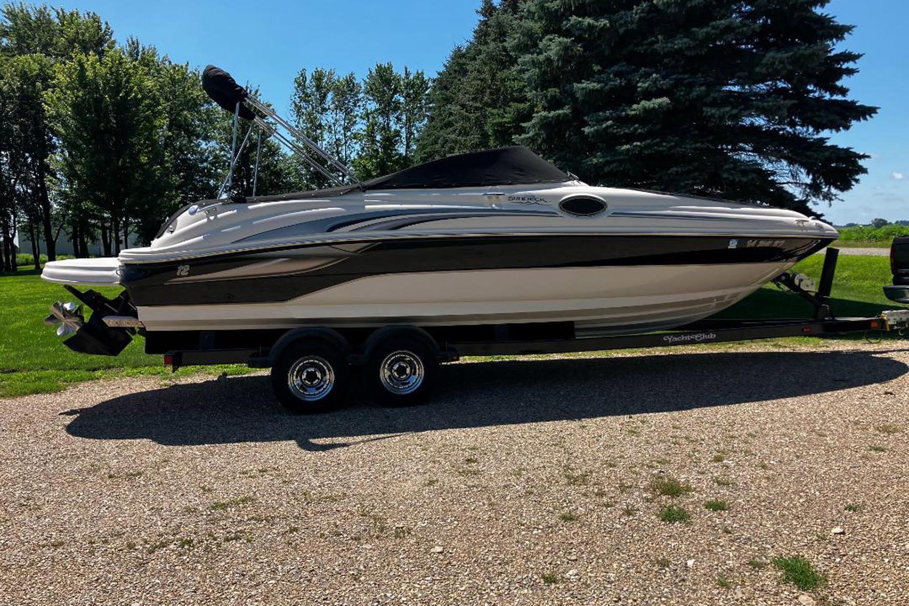 Sea Ray 240 Sundeck 2002 Sea Ray 240 Sundeck boat on trailer, parked outdoors with trees in background.