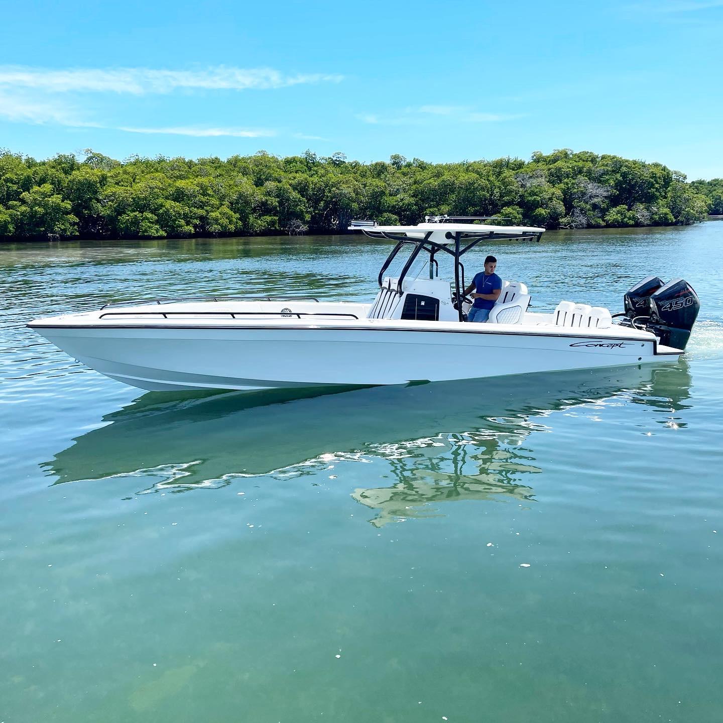 Concept 32' CC 2022 Concept 32' CC boat on calm water, surrounded by lush greenery.