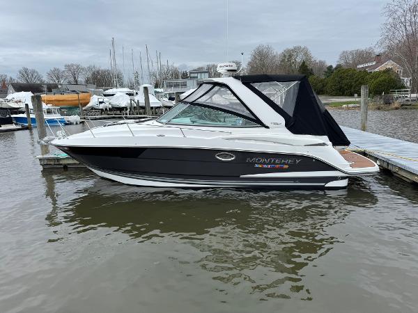 Monterey 295 Sport Yacht 2020 Monterey 295 Sport Yacht docked in a marina, featuring sleek design and black canopy.