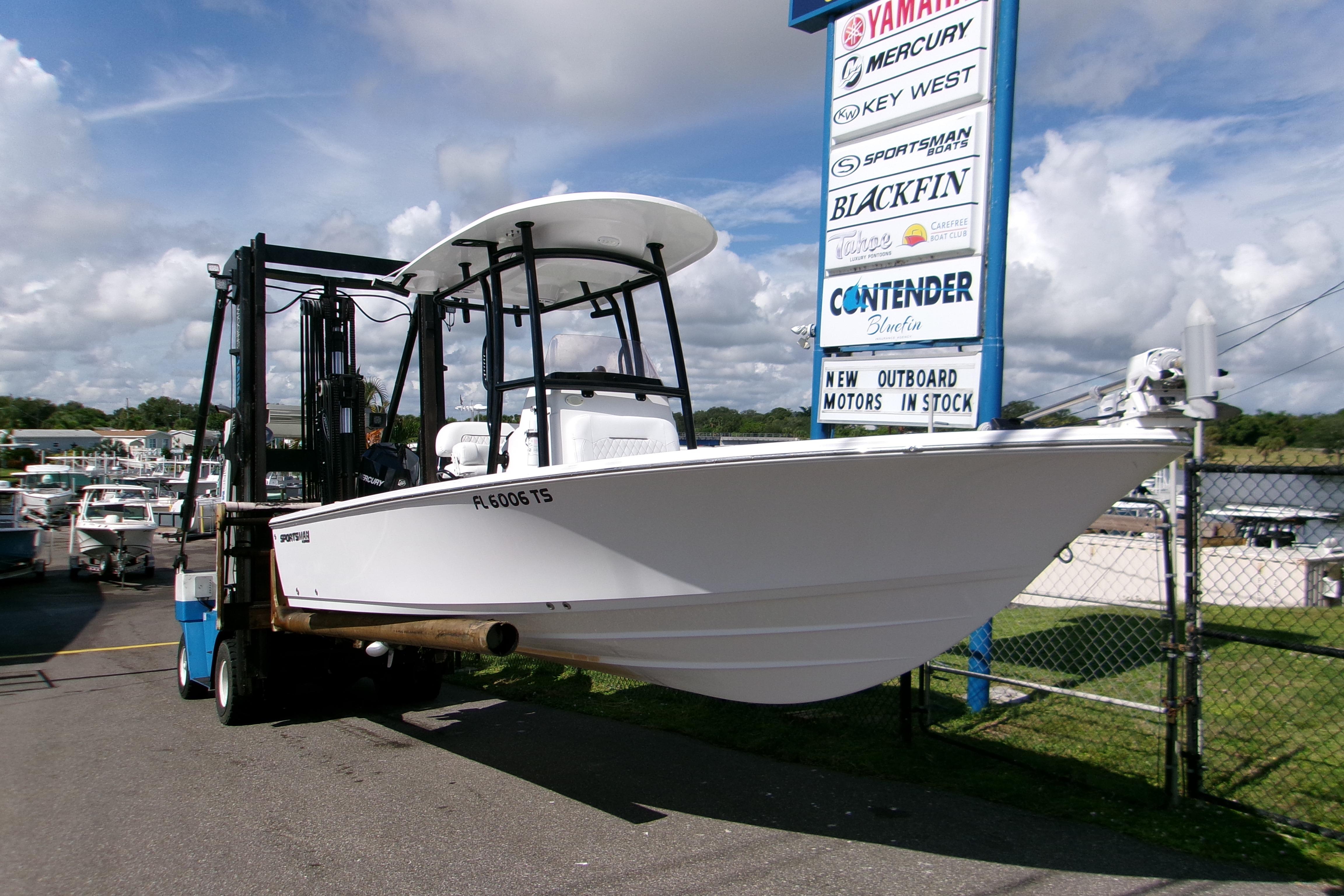 Sportsman Masters 227 Bay Boat 2024 Sportsman Masters 227 Bay Boat on forklift near dealership sign.
