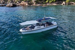 Nimbus T9 Nimbus T9 boat, 2023 model, anchored in clear blue water near rocky shoreline.