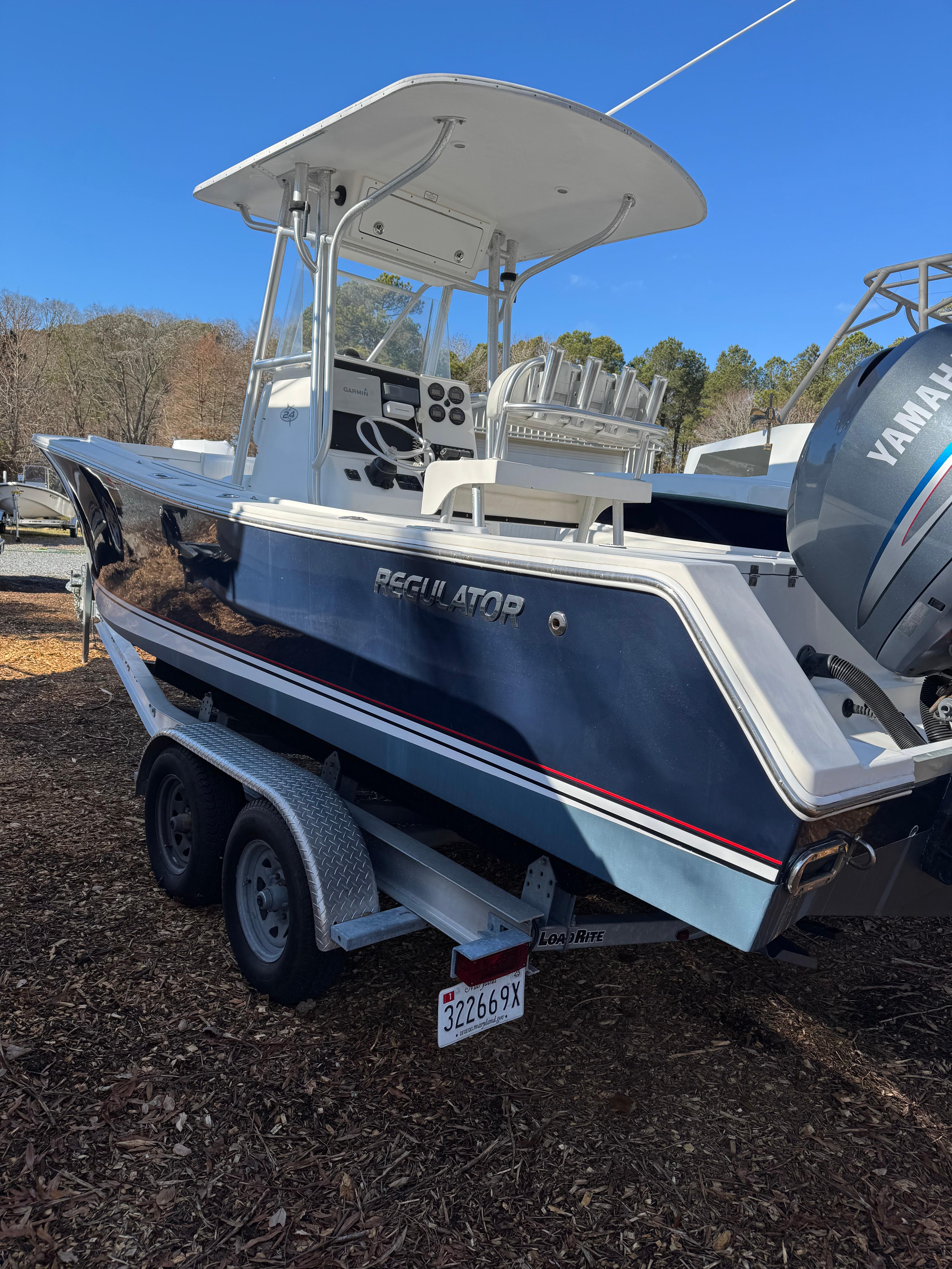 Regulator 24 Fs 2004 Regulator 24 FS boat on trailer with Yamaha engine, parked outdoors.