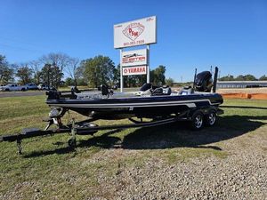 Skeeter 21i 2013 Skeeter 21i boat on trailer near dealership sign, clear blue sky.