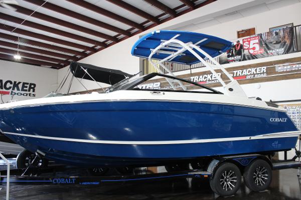 Cobalt R6 2025 Cobalt R6 boat in showroom, blue and white design, on trailer.
