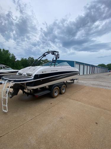 Four Winns F Series F244 2008 Four Winns F Series F244 boat on a trailer near storage units.