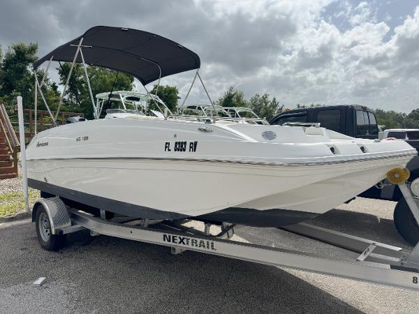 Hurricane SunDeck Sport 188 OB 2019 Hurricane SunDeck Sport 188 OB boat on trailer, parked outdoors under cloudy sky.