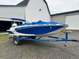 Glastron GTD 180 2019 Glastron GTD 180 boat on trailer, blue and white, parked near a barn.