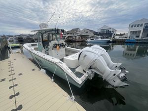Cobia 280 Center Console 2024 Cobia 280 Center Console boat docked, featuring twin Yamaha engines, under a cloudy sky.