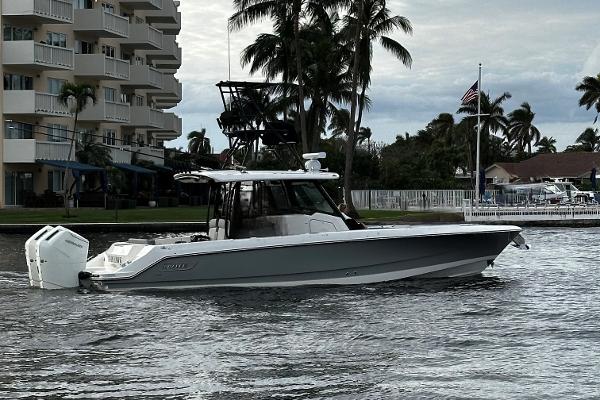 Boston Whaler 360 Outrage 2023 Boston Whaler 360 Outrage boat cruising near waterfront buildings and palm trees.