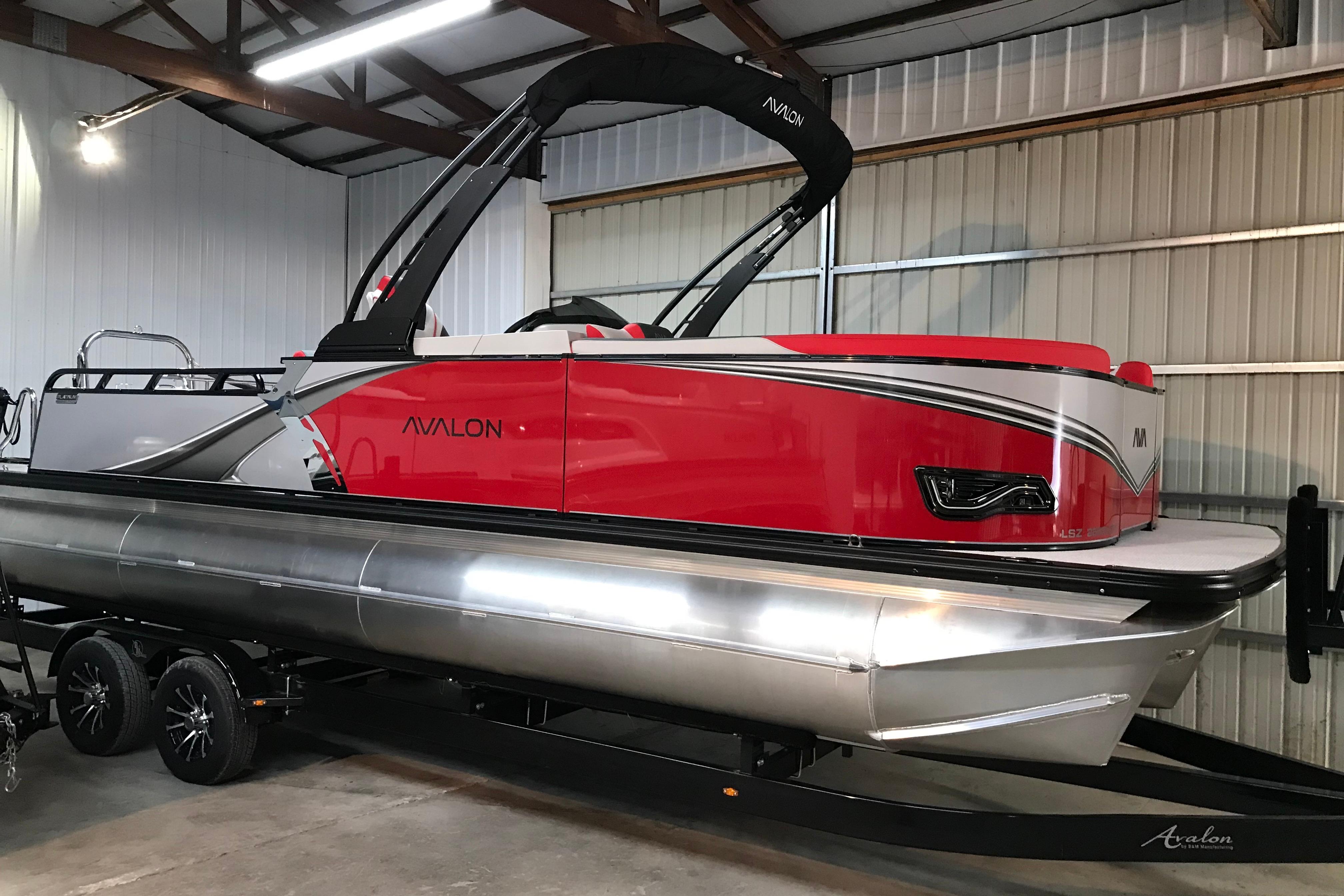 Avalon LSZ ENTERTAINER 2026 Avalon LSZ Entertainer pontoon boat in a garage, featuring sleek red design.