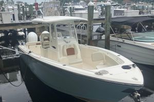 Cobia 280 Center Console 2024 Cobia 280 Center Console boat docked at marina, showcasing sleek design and spacious deck.