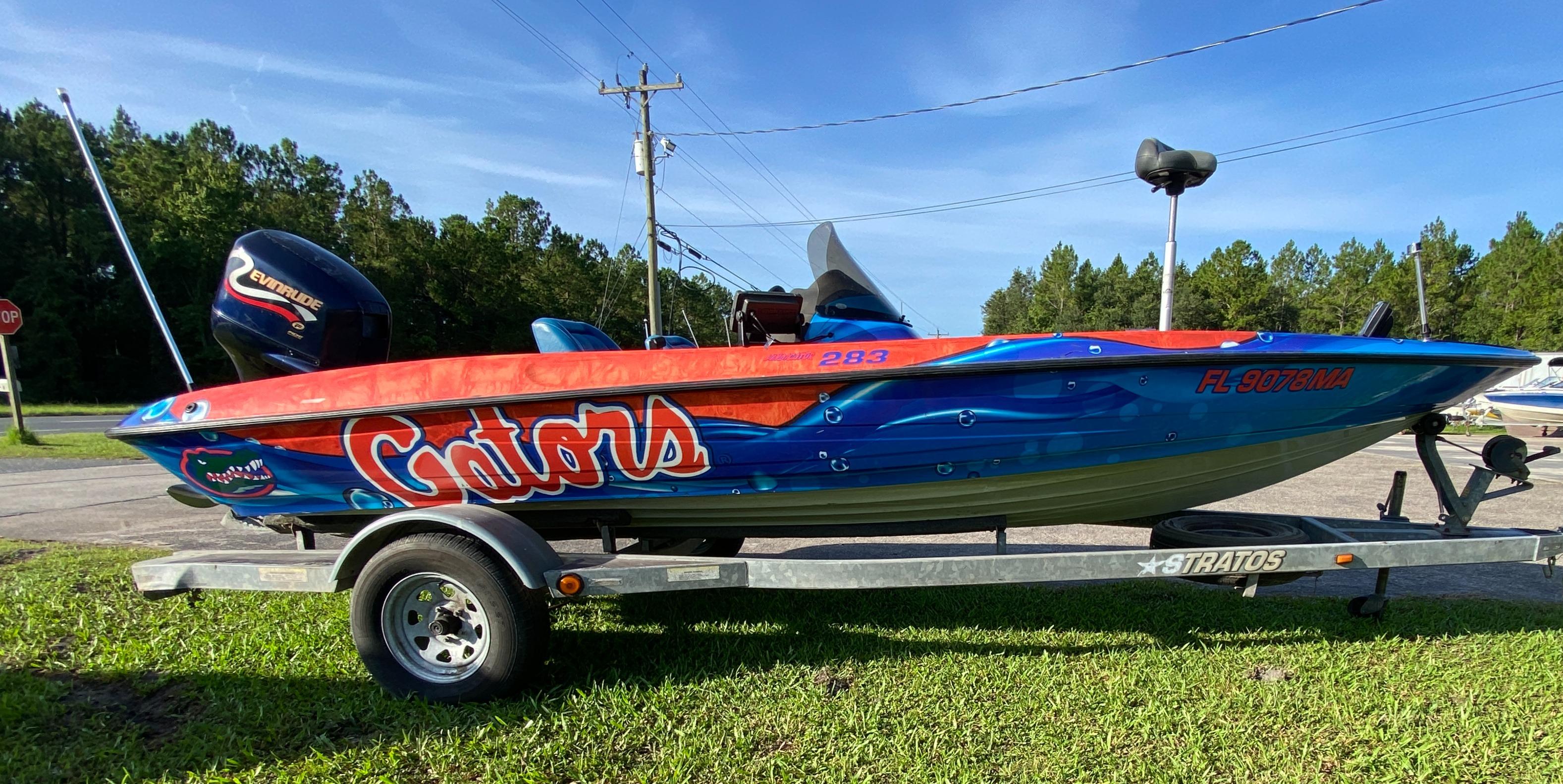 Stratos 283 1999 Stratos 283 boat with vibrant "Gators" design on trailer, parked on grass.