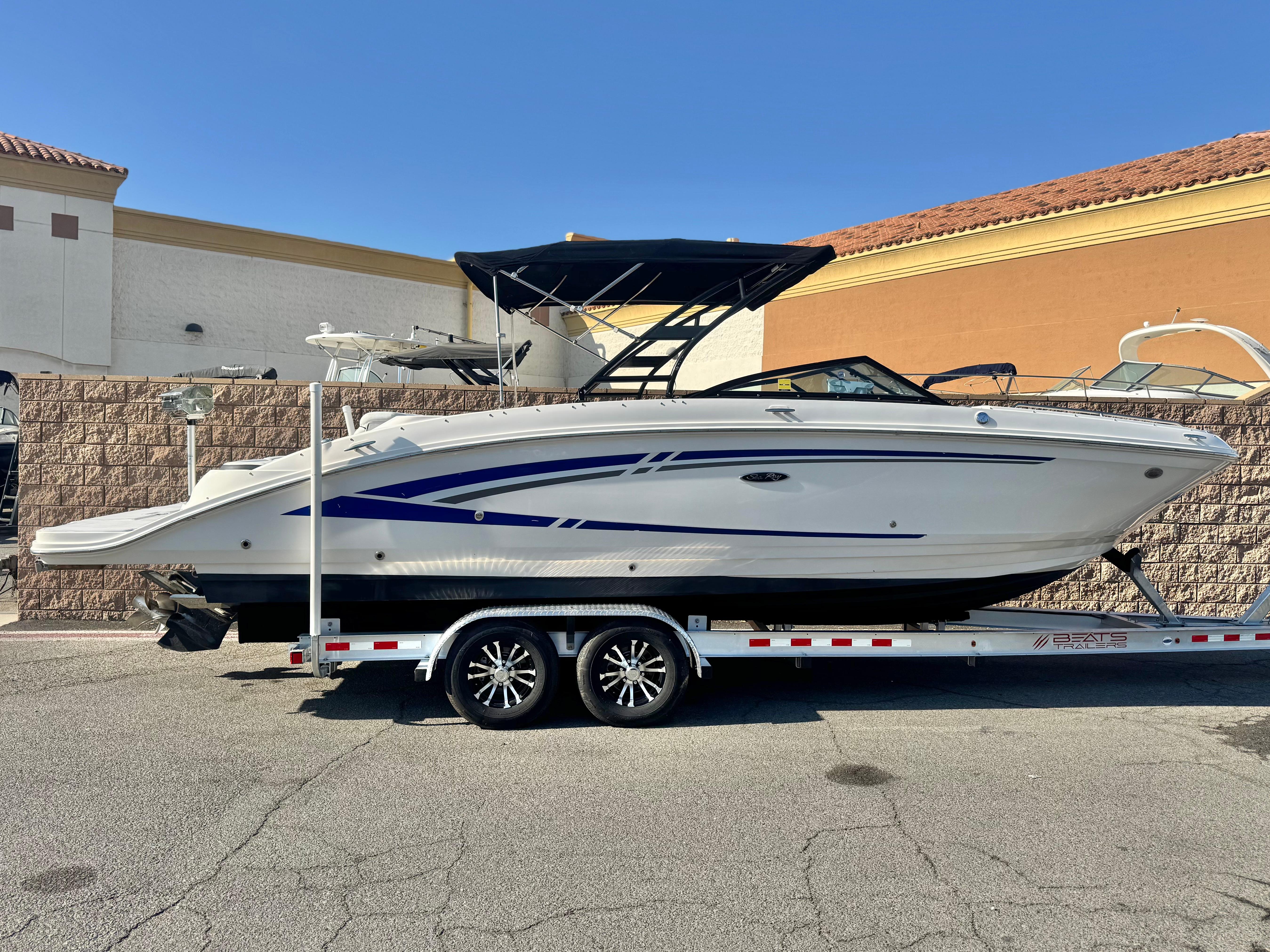 Sea Ray SDX 270 2015 Sea Ray 270 SDX boat on trailer, parked outdoors under clear blue sky.