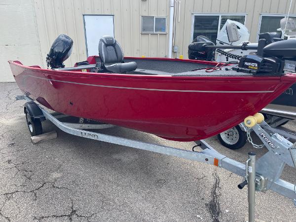 Lund 1650 Angler Tiller 2023 Lund 1650 Angler Tiller boat in red on a trailer.
