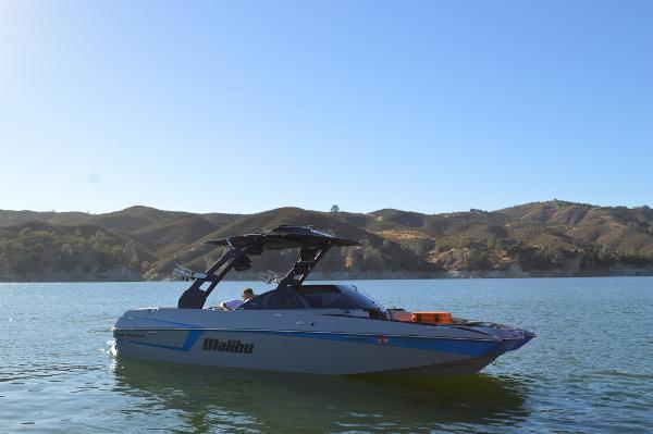 Malibu Wakesetter 22 MXZ 2017 Malibu Wakesetter 22 MXZ boat on a serene lake with hills in the background.