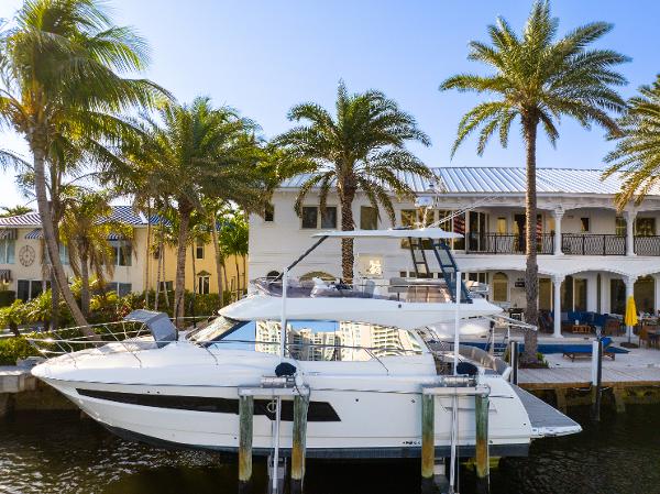 Prestige 460 Fly 2023 Prestige 460 Fly yacht docked by palm trees and luxury waterfront homes.