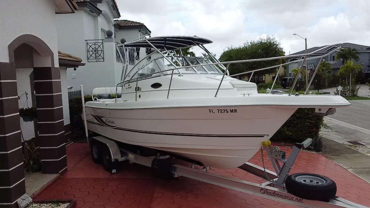 Cobia 250 Walk-Around 2004 Cobia 250 Walk-Around boat on trailer in residential driveway.