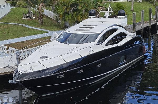 Sunseeker Predator 64 2010 Sunseeker Predator 64 yacht docked by lush greenery.