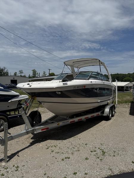 Regal 26 OBX 2020 Regal 26 OBX boat on trailer, parked outdoors under cloudy sky.