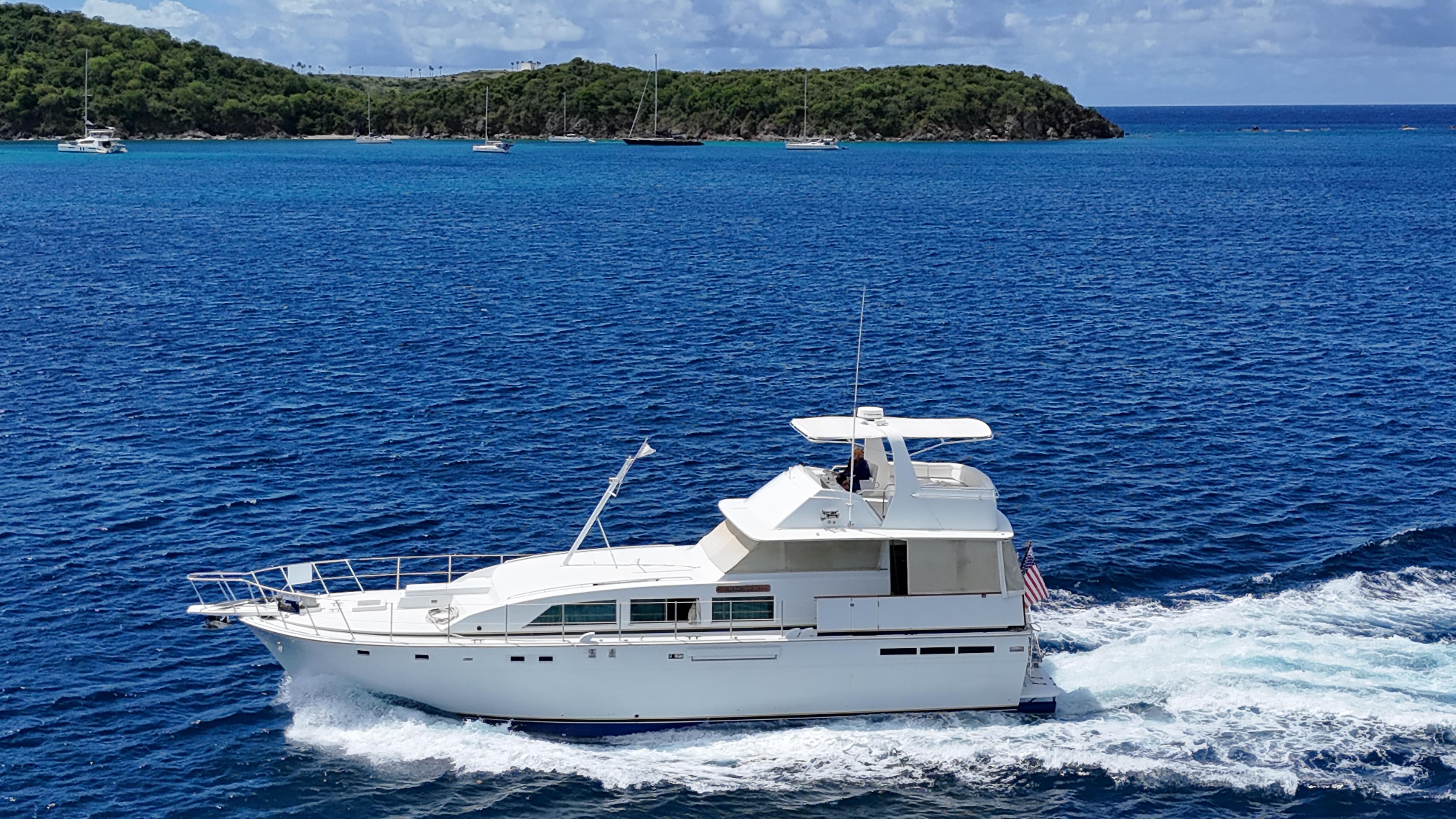 Bertram 58 Motor Yacht 1980 Bertram 58 Motor Yacht cruising on blue ocean near lush green island.
