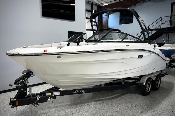 Sea Ray SPX 210 2025 Sea Ray SPX 210 boat on trailer in showroom, sleek white design.