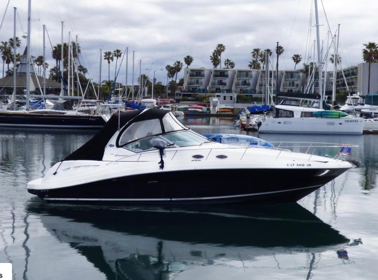Sea Ray 340 2007 Sea Ray 340 boat docked in a marina with sailboats and palm trees.