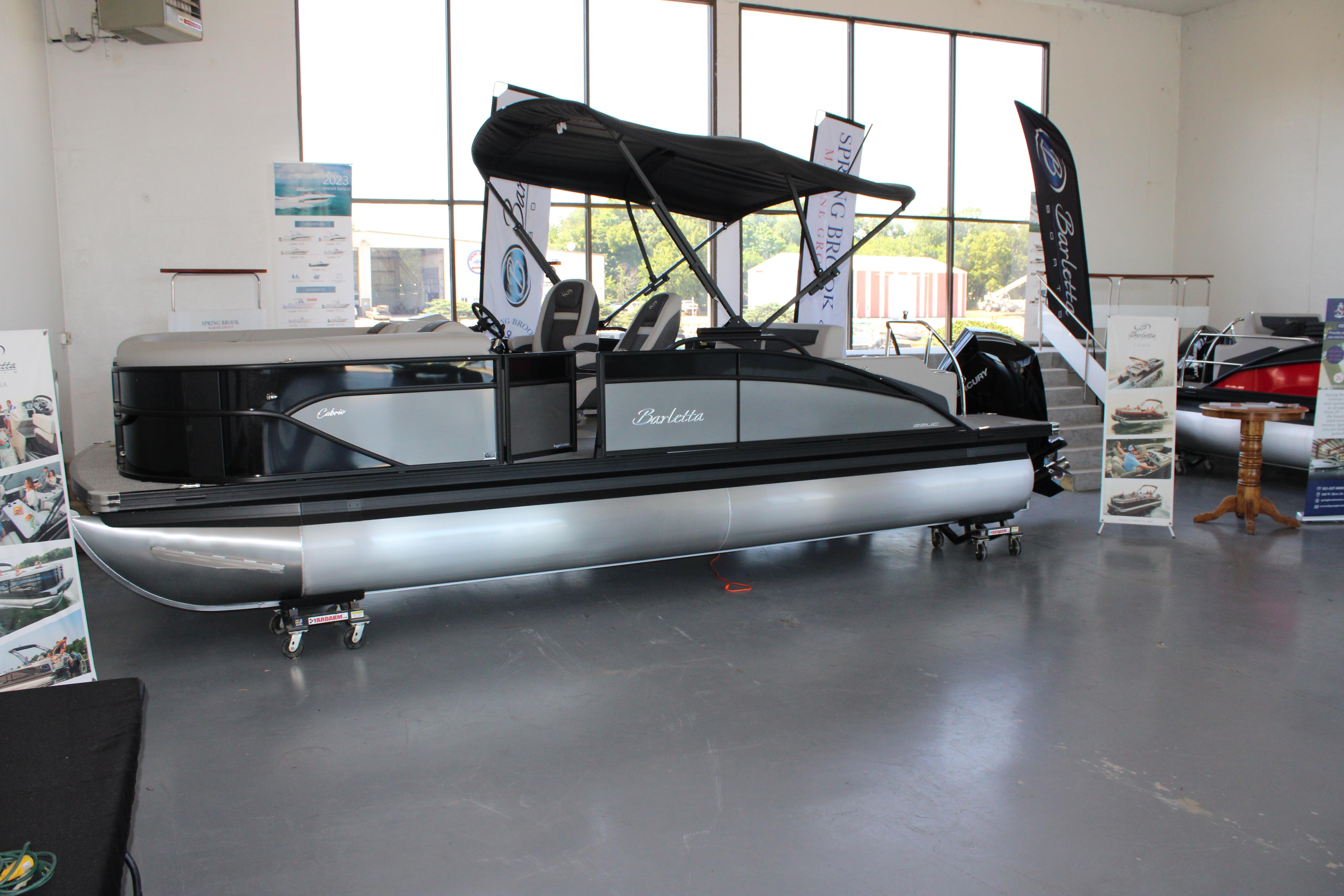 Barletta Cabrio 22UC 2024 Barletta Cabrio 22UC pontoon boat displayed indoors with promotional banners.