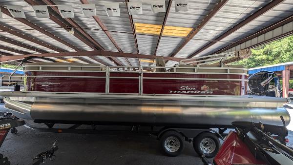 Sun Tracker Party Barge 24 DLX 2025 Sun Tracker Party Barge 24 DLX pontoon boat in covered storage.