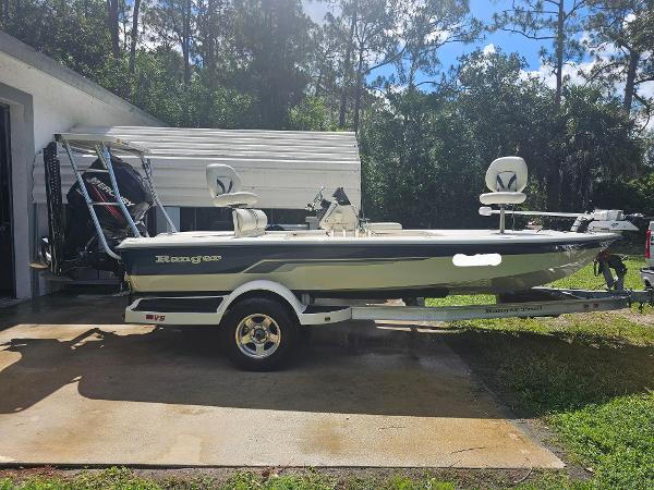 Ranger 191 Cayman 2004 Ranger 191 Cayman boat on trailer, parked outdoors near a garage.