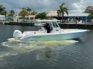 Everglades 295 Center Console 2020 Everglades 295 Center Console boat cruising on a canal with palm trees in the background.