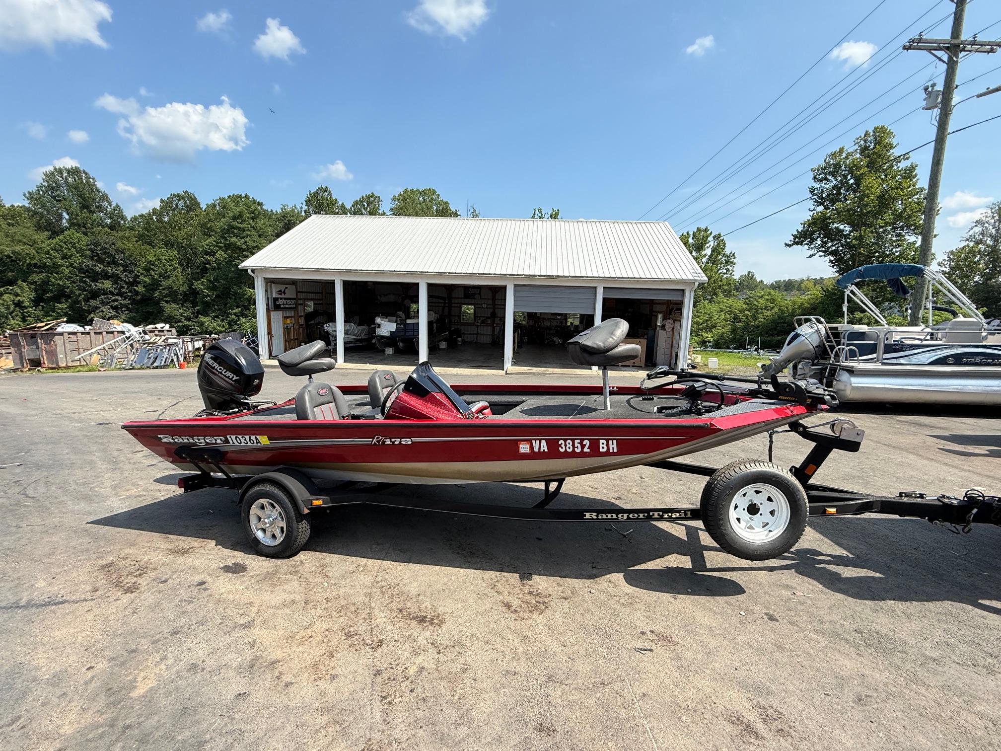 Ranger RT178 2014 Ranger RT178 boat on trailer, parked outdoors near a garage under a clear sky.