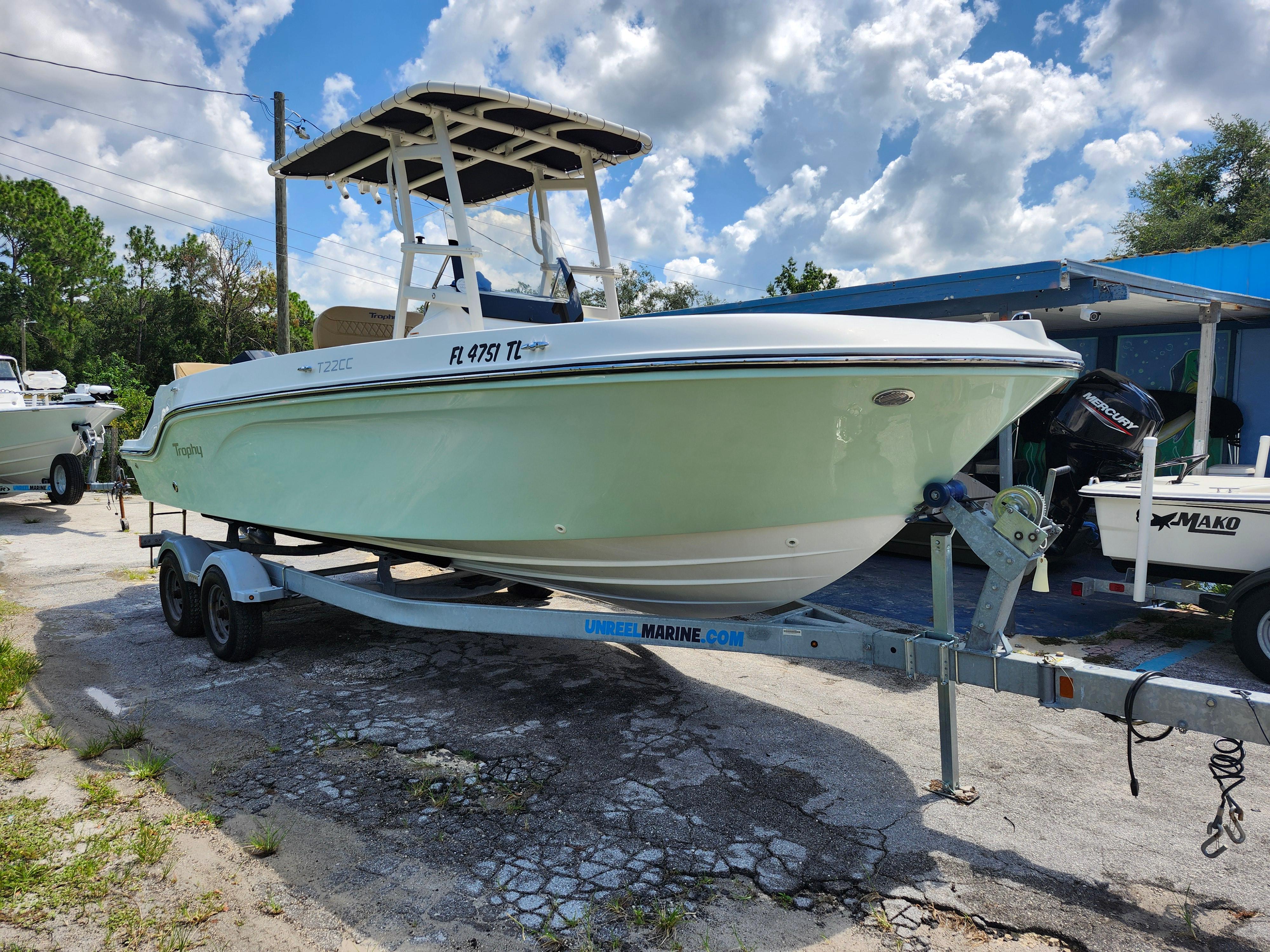Bayliner Trophy T22CC 2022 Bayliner Trophy T22CC boat on trailer under a partly cloudy sky.