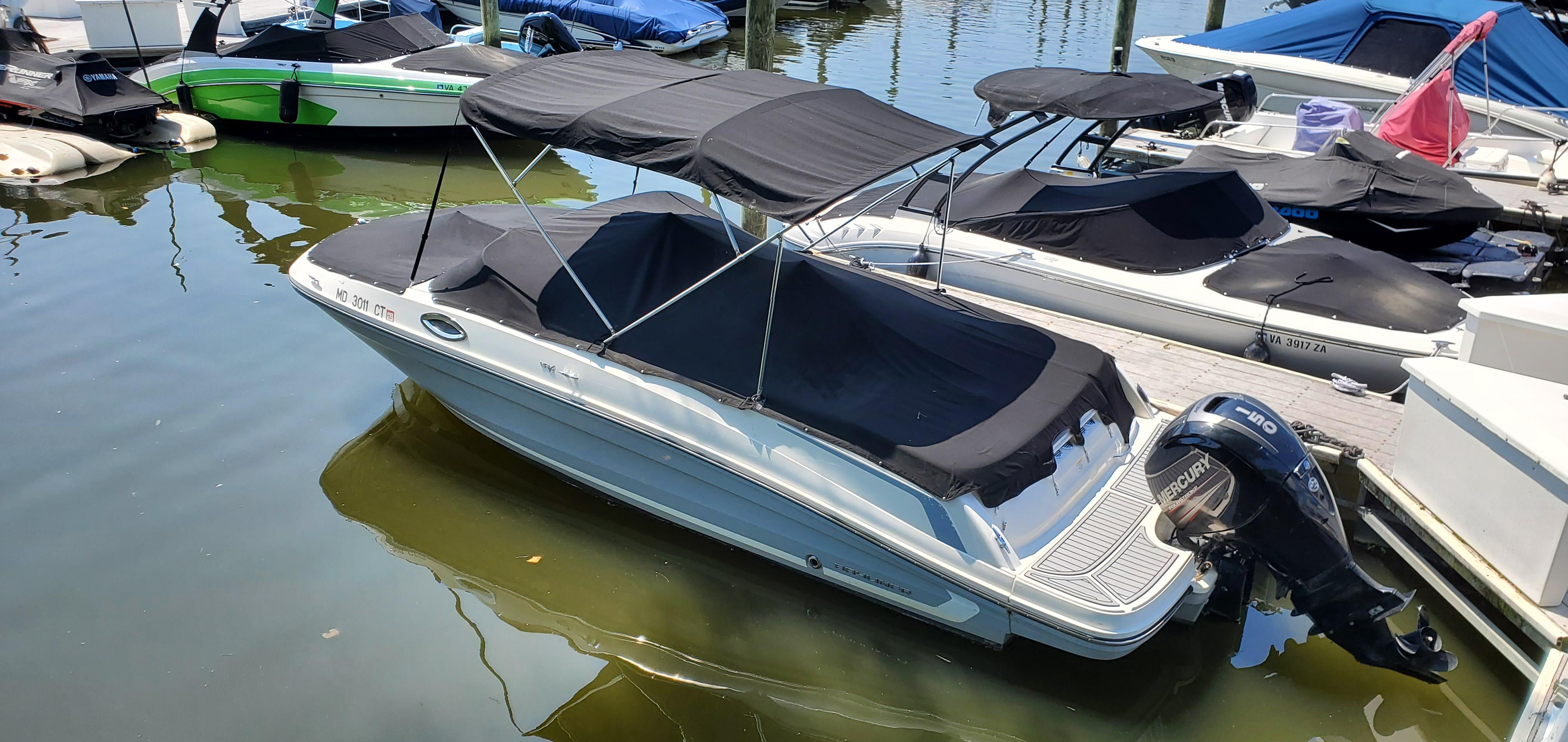 Bayliner VR6 Bowrider OB 2019 Bayliner VR6 Bowrider OB docked with black canopy and Mercury outboard motor.