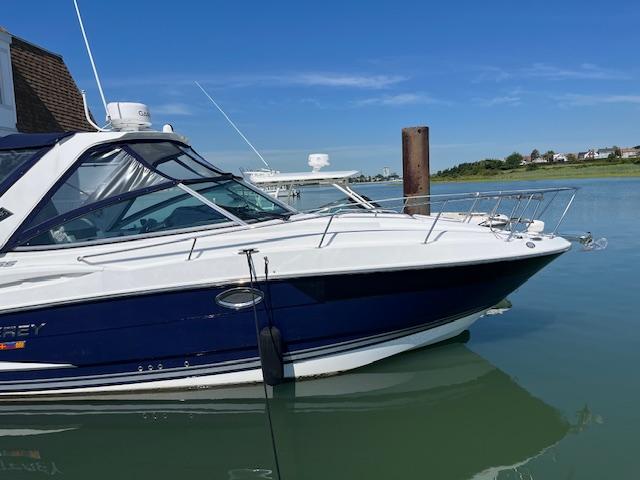 Monterey 295 Sport Yacht 2022 Monterey 295 Sport Yacht docked on calm water under clear blue sky.