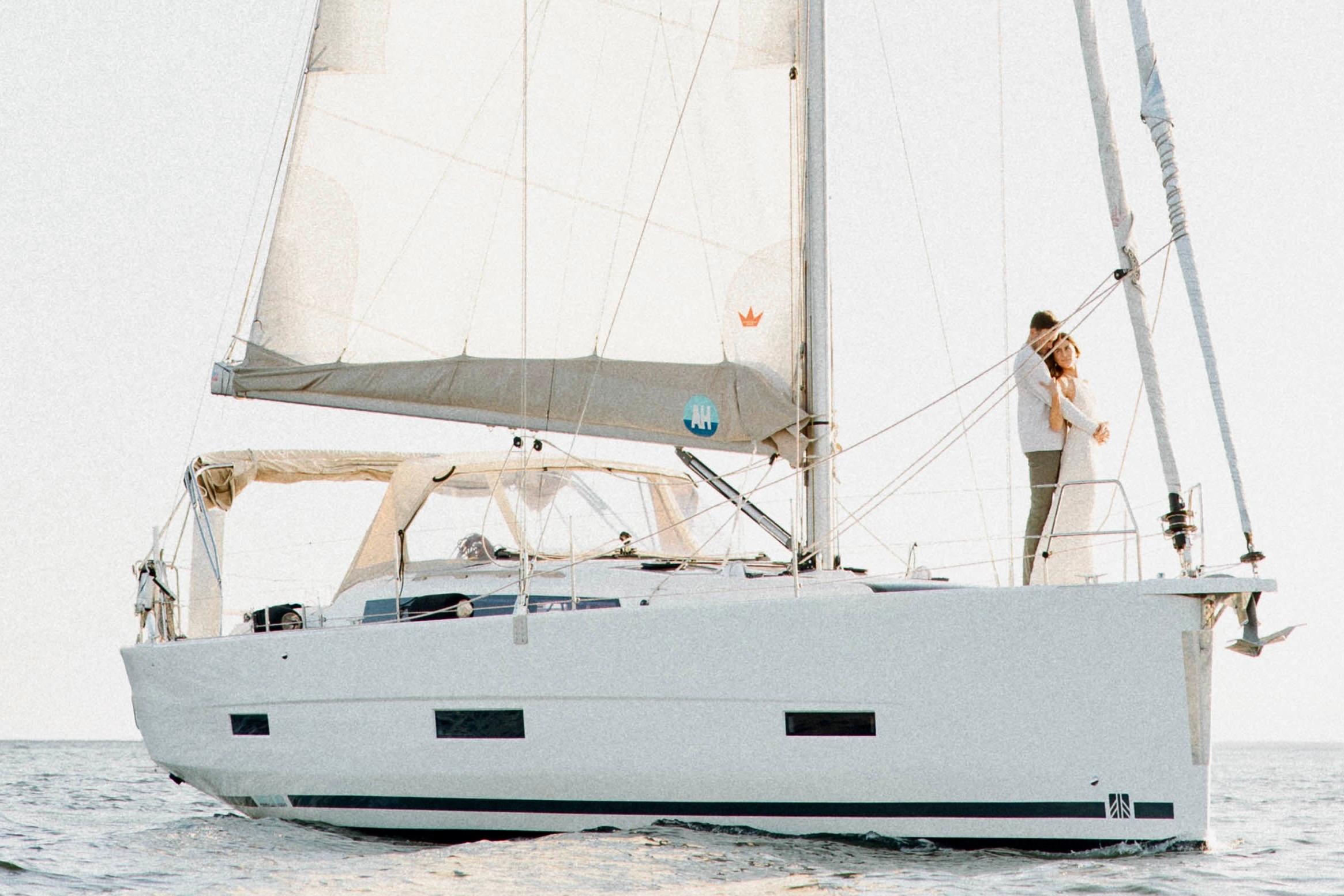 Dufour 430 2020 Dufour 430 sailboat with couple on deck, sailing on calm waters.