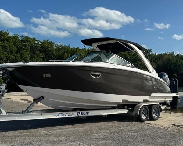 Regal 29 OBX 2017 Regal 29 OBX boat on trailer, parked outdoors under a clear sky.