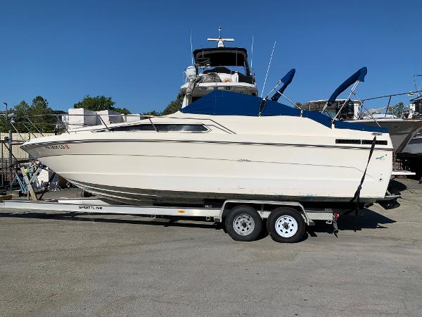 Sea Ray 268 Sundancer 1987 Sea Ray 268 Sundancer boat on a trailer in a marina.