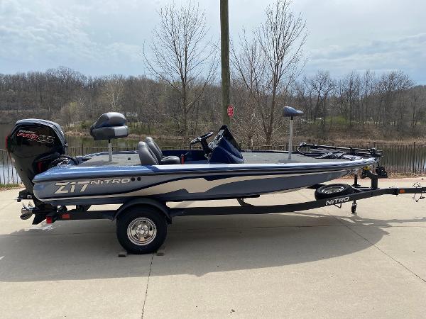 Nitro Z17 2025 Nitro Z17 fishing boat on trailer, parked outdoors near a lake.