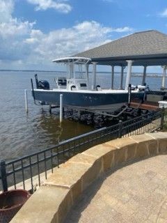 Tidewater 2300 Carolina Bay 2023 Tidewater 2300 Carolina Bay boat docked by a lakeside pavilion.