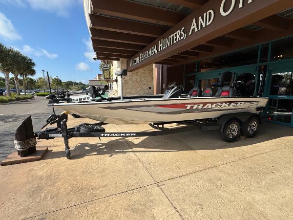Tracker Savage 215 2025 Tracker Savage 215 boat on trailer outside a store, sunny day.